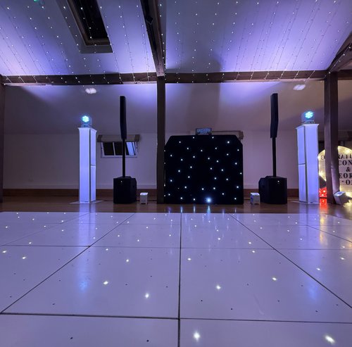 2 White LED starlit dancefloor with DJ booth and speakers set up under fairy-light drapes