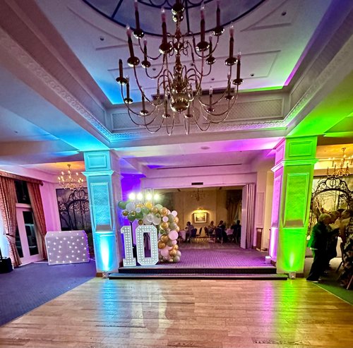 2 Gold light-up initial letters and pink neon telephone box photobooth on a manor house staircase