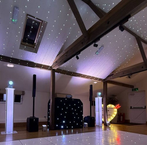 3 DJ booth and speaker set-up under a starlit ceiling canopy with an illuminated love heart sign