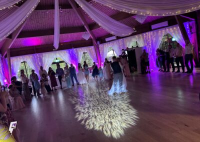 Bride and groom dancing on a white LED dancefloor with heart light pattern, guests watching, at The Ravenswood