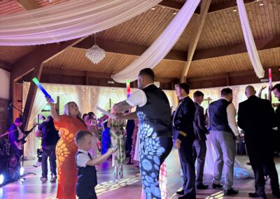 Guests dancing with glow sticks during the evening reception at The Ravenswood
